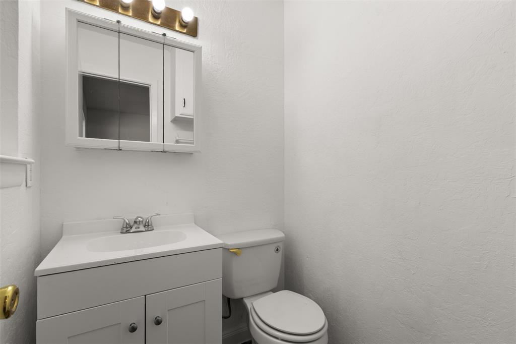 White vanity with double-door cabinetry, integrated sink, and chrome-finish faucet