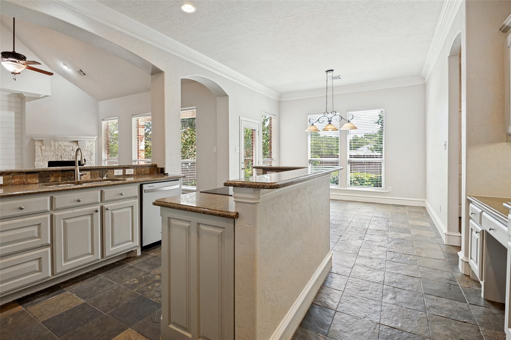 Kitchen featuring granite countertops, light-toned cabinetry, tile flooring, and integrated appliances