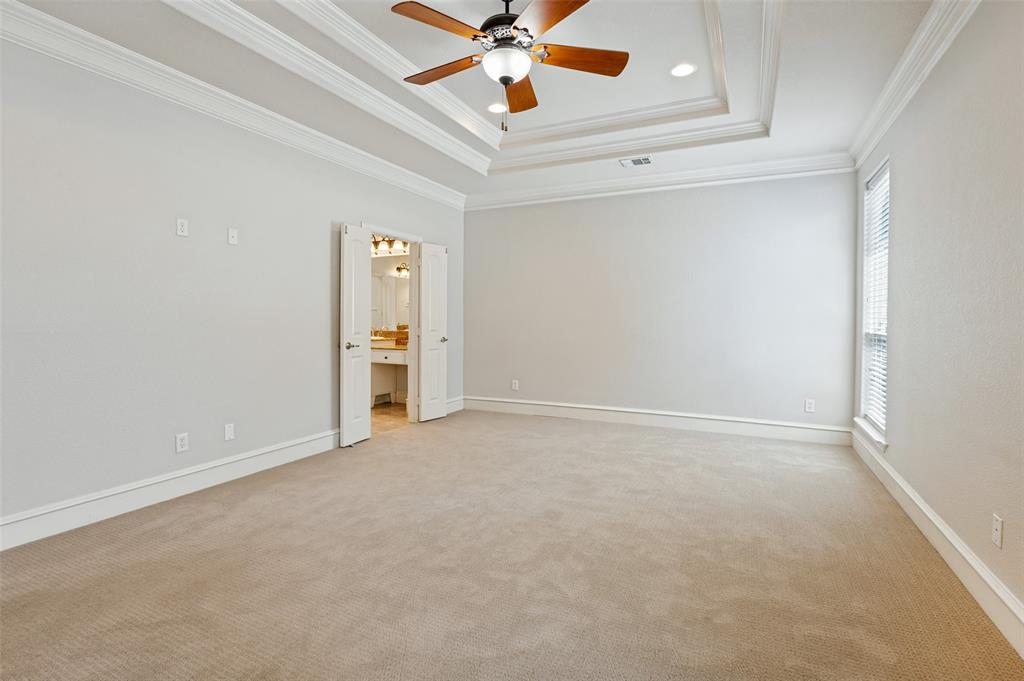 Spacious room featuring tray ceiling with a ceiling fan, recessed lighting, carpeted flooring, and a window with blinds