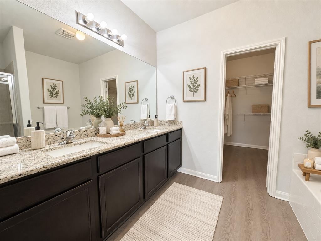 Dual vanity with granite-style countertops, dark wood-finish cabinetry, and undermount sinks Dual vanity with granite-style countertops, dark wood-finish cabinetry, and undermount sinks
