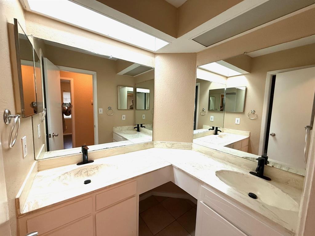 Dual basin vanity with integrated sinks, expansive counter space, and wall-mounted mirrors