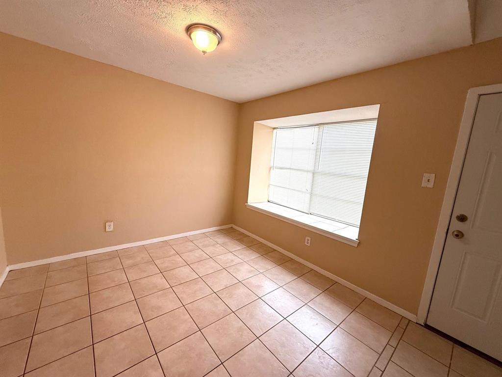 Tile flooring, neutral wall tones, window with horizontal blinds, and a ceiling-mounted light fixture