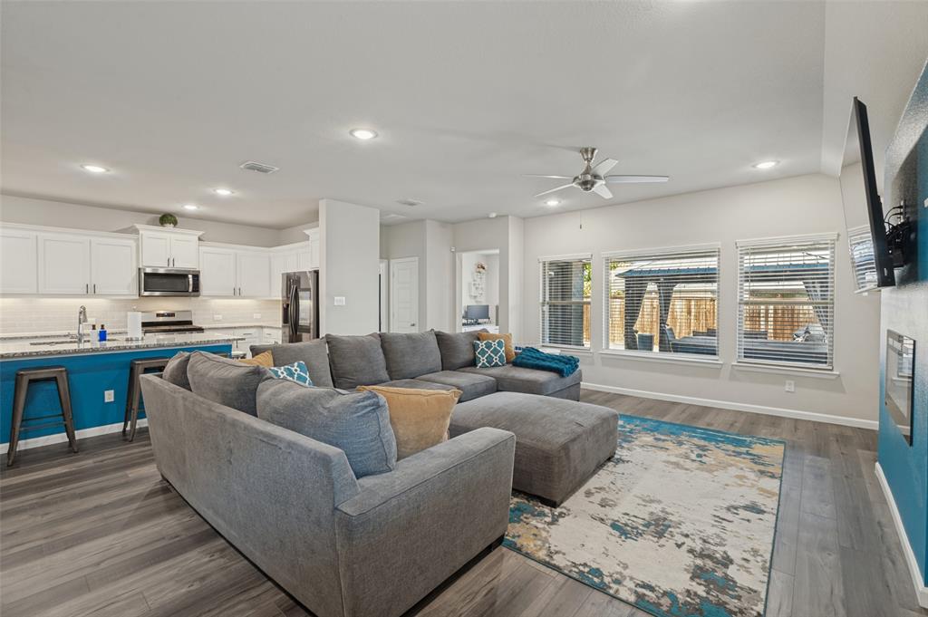 Open-concept living area featuring wood-finish flooring, recessed lighting, and a ceiling fan Open-concept living area featuring wood-finish flooring, recessed lighting, and a ceiling fan