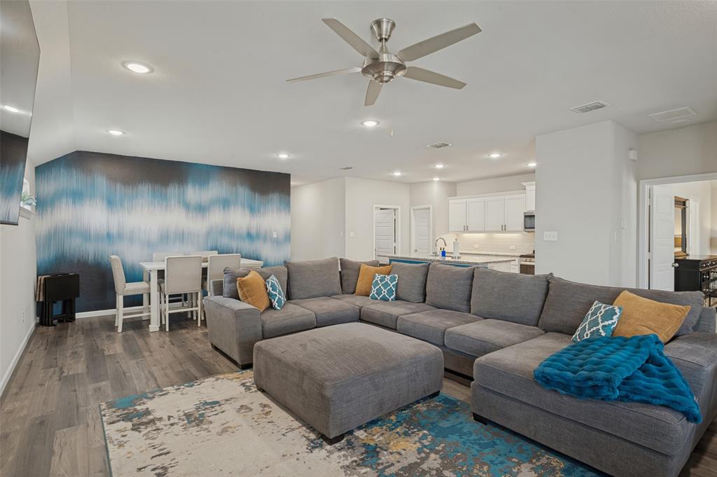 Open-concept living area with wood-finish flooring, recessed lighting, and a ceiling fan Open-concept living area with wood-finish flooring, recessed lighting, and a ceiling fan