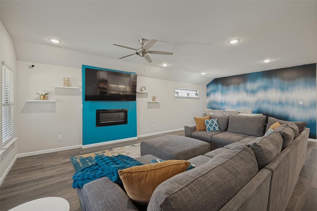 Vaulted ceiling, recessed lighting, wood-finish flooring, built-in fireplace, and a ceiling fan Vaulted ceiling, recessed lighting, wood-finish flooring, built-in fireplace, and a ceiling fan
