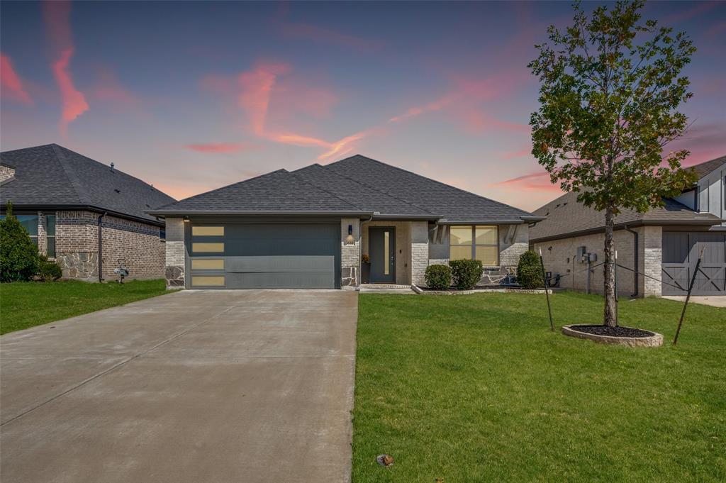 Single-story residence featuring a dark gray shingle roof and a two-car garage with horizontal paneling