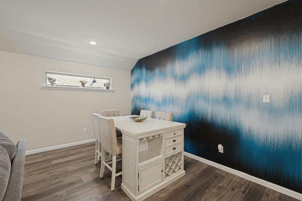 Recessed ceiling lighting, wood-finish flooring, accent wall with graphic pattern, horizontal window, and white trim molding Recessed ceiling lighting, wood-finish flooring, accent wall with graphic pattern, horizontal window, and white trim molding