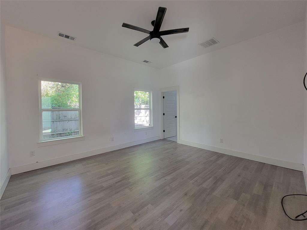 Vaulted ceilings, wood-finish flooring, and a matte black ceiling fan