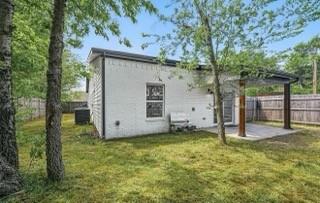 White-painted brick exterior featuring a covered patio, wooden support columns, and perimeter wood fencing