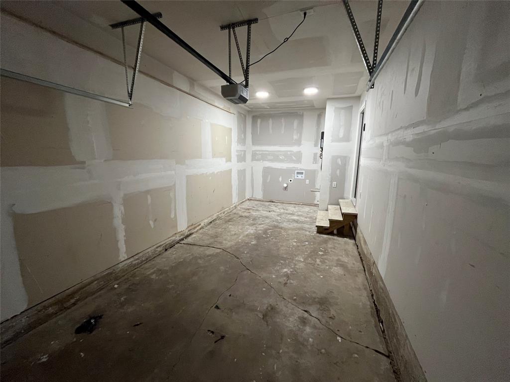 Garage space featuring concrete flooring, unpainted drywall, recessed lighting, and integrated laundry hookups