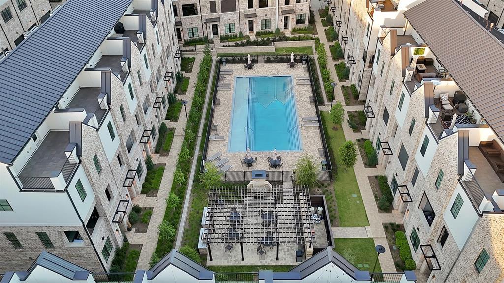 Central rectangular swimming pool, structured landscaping, paved walkways, and a covered outdoor seating area