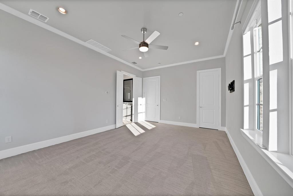Spacious room featuring carpeting, recessed lighting, a ceiling fan, and multiple windows