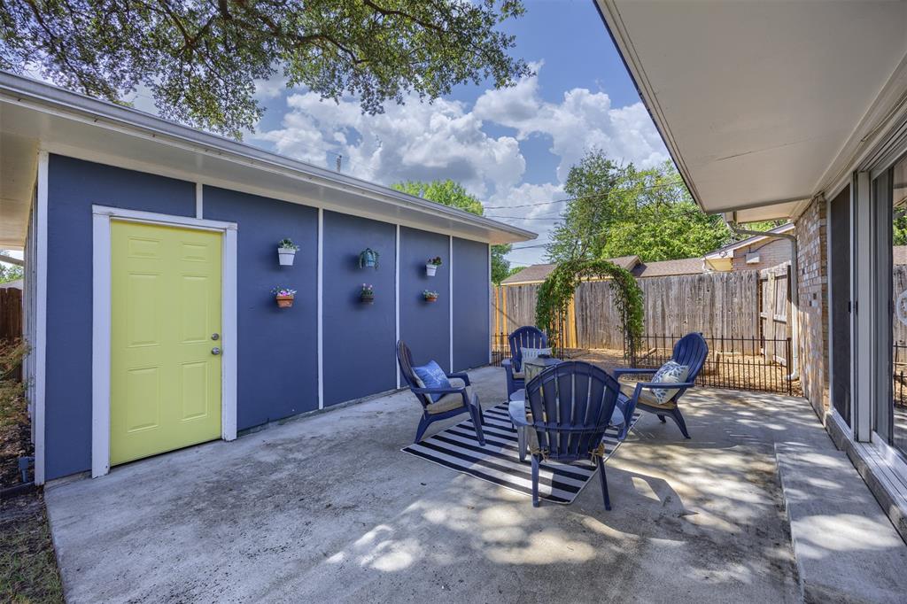 Concrete patio with an overhead awning and a vibrant yellow exterior door