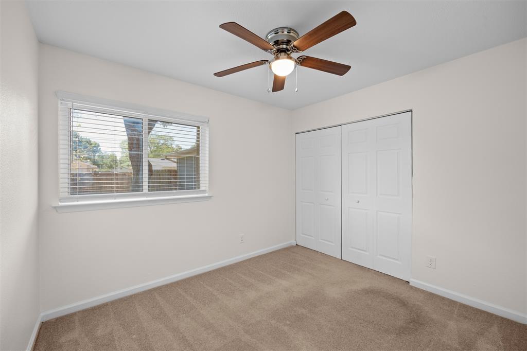 Neutral-toned carpet flooring, white walls, and a window with blinds provide natural light