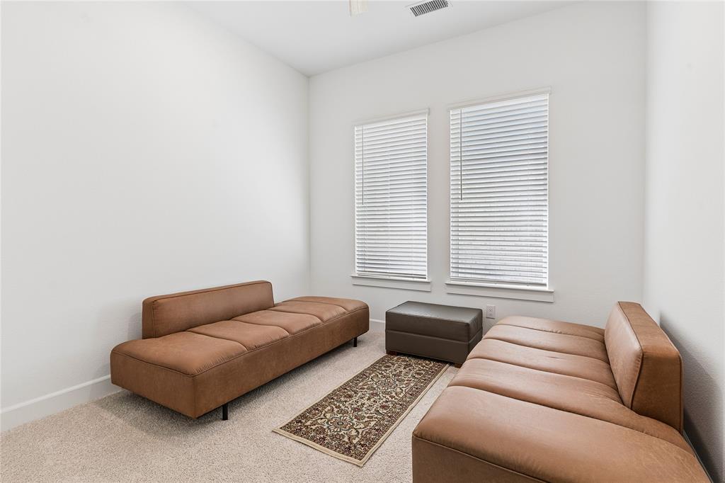 Light-colored carpeting, white walls, and two windows with horizontal blinds