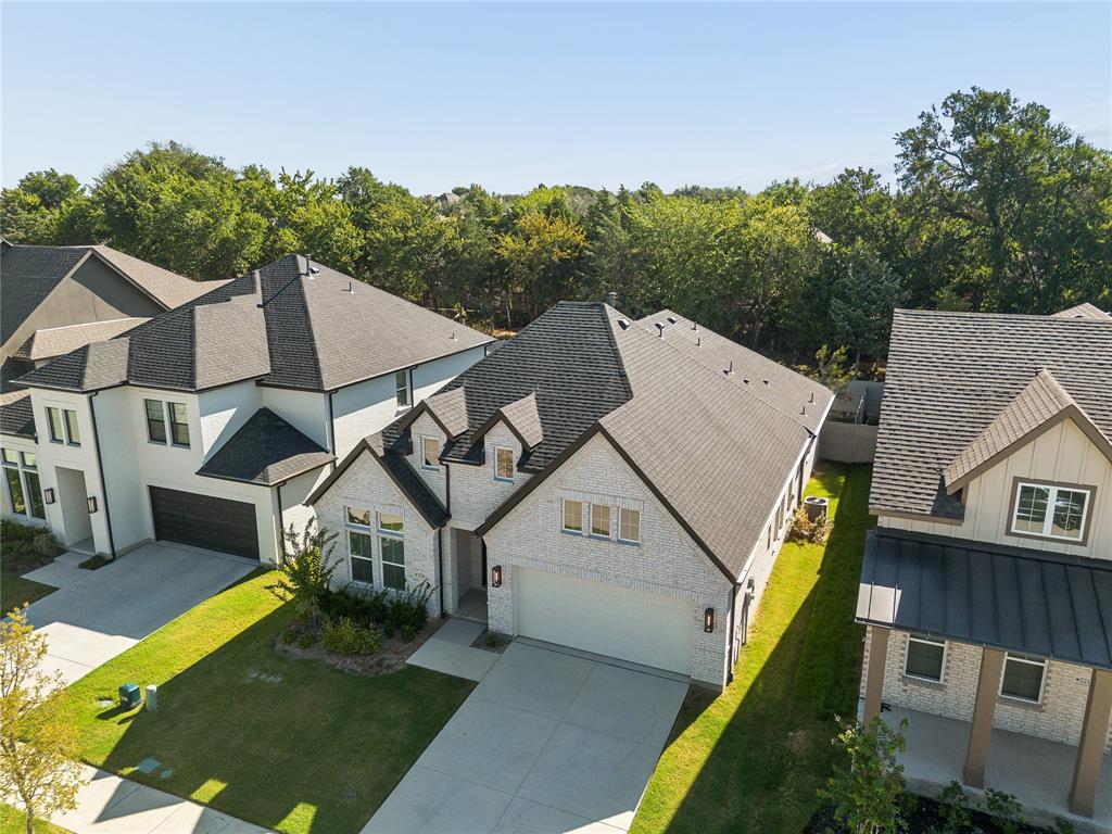 Contemporary residence with a light brick exterior, dark-toned roof, and an attached garage
