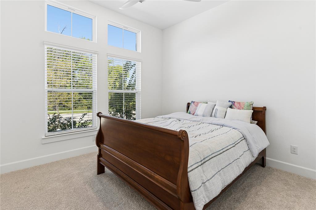 Spacious interior with high ceilings, light-toned carpeting, and white walls