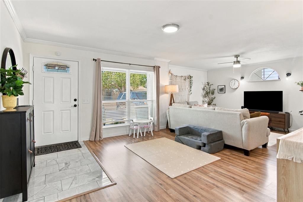 Entryway with tile flooring, wood-finish flooring, a front door with decorative glass, and a large window with blinds Entryway with tile flooring, wood-finish flooring, a front door with decorative glass, and a large window with blinds