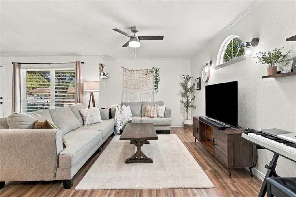 Wood-finish flooring, ceiling fan with integrated lighting, arched window, and recessed wall sconces Wood-finish flooring, ceiling fan with integrated lighting, arched window, and recessed wall sconces