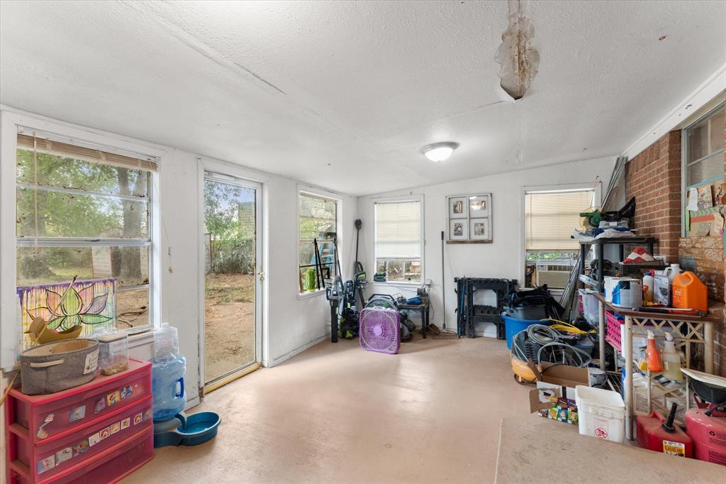 Enclosed porch featuring multiple windows, exposed brick wall, and direct exterior access
