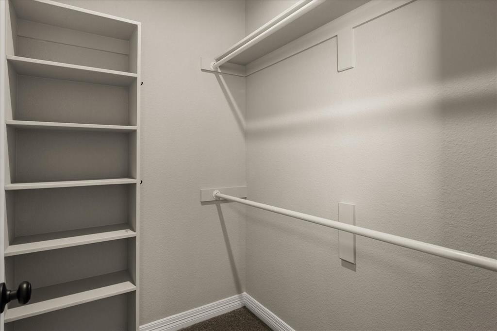 Built-in shelving, two clothing rods, and carpeting