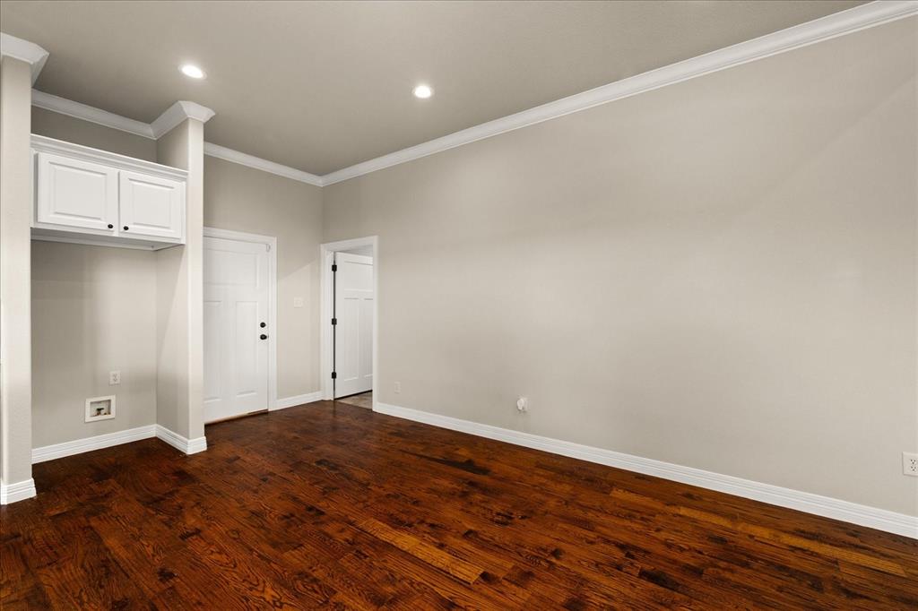 Hardwood flooring, crown molding, recessed lighting, white built-in cabinetry, and white paneled doors