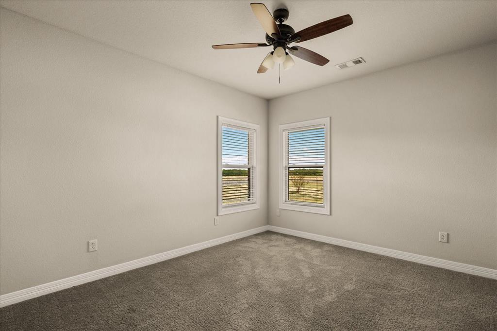 Recessed windows with blinds, ceiling fan with light fixture, neutral wall color, and carpeted flooring