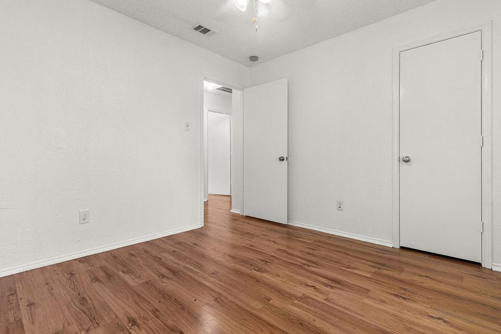 Interior space featuring wood-finish flooring, white walls, and interior passage doors
