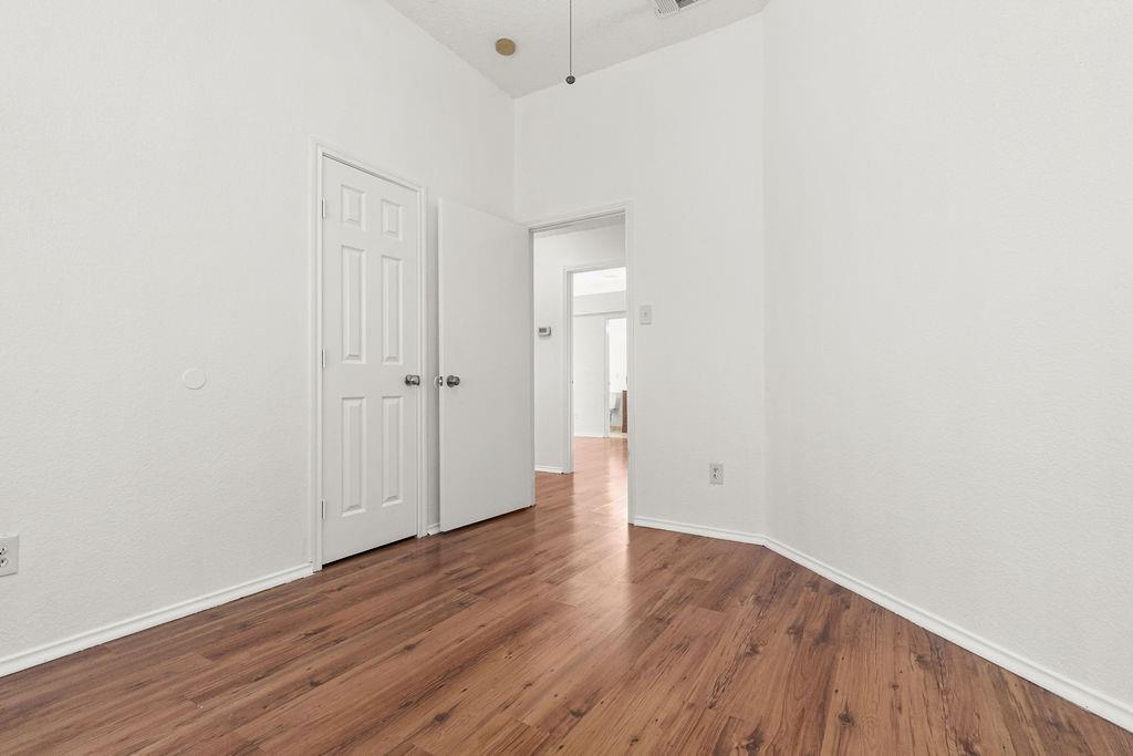Interior space featuring wood-finish flooring, high ceilings, and white paneled doors