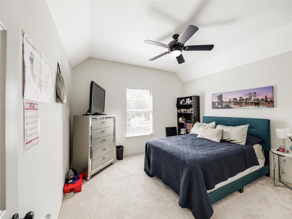 Vaulted ceiling with a black ceiling fan, light-colored walls, window with blinds, and light carpet flooring
