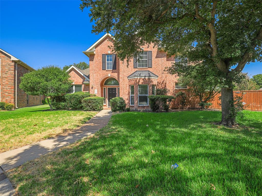 Brick exterior with arched entryway, bay window, and dark window shutters