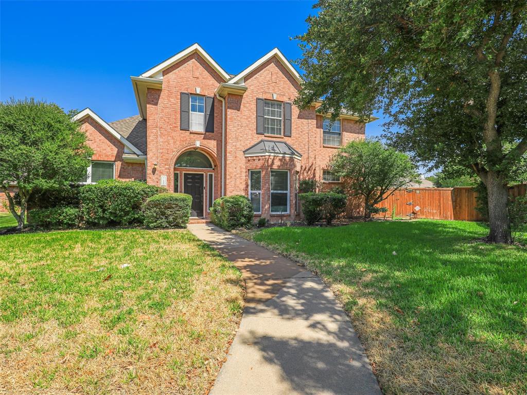 Brick exterior with multiple gables, arched entry, black paneled shutters, and established landscaping Brick exterior with multiple gables, arched entry, black paneled shutters, and established landscaping
