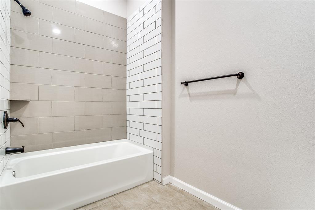 Bathroom with tile patterned flooring, tub / shower combination, and baseboards