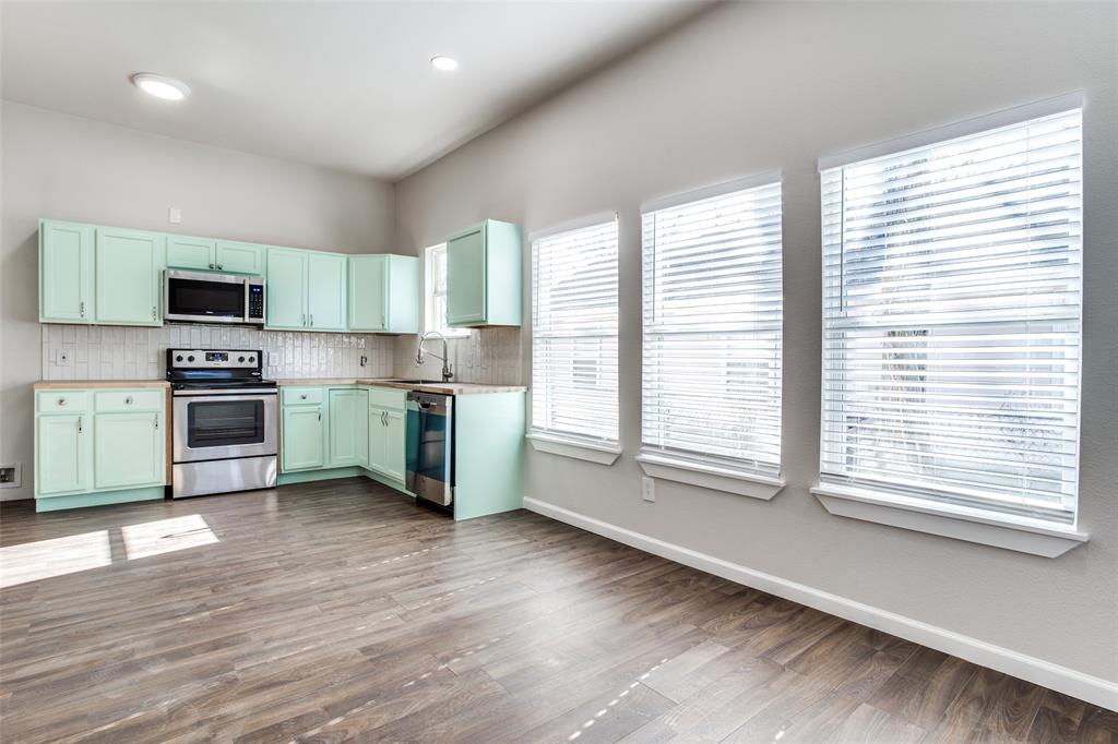 Kitchen featuring backsplash, a sink, stainless steel appliances, and baseboards