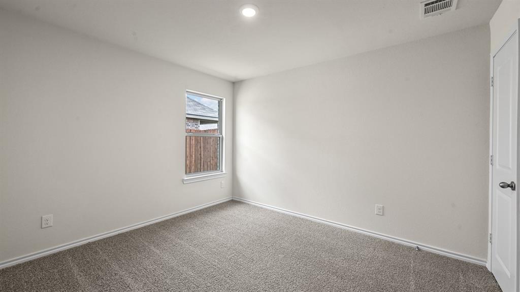 Neutral wall finishes, recessed lighting, window with white trim, gray carpeting, and a white interior door