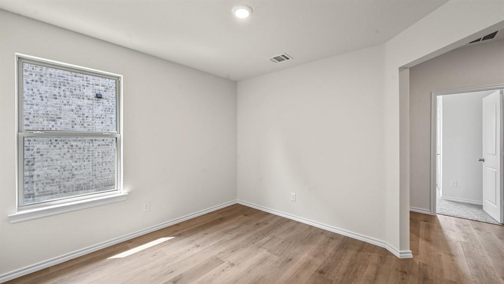 Recessed lighting, light wood-finish flooring, white walls, and a double-hung window