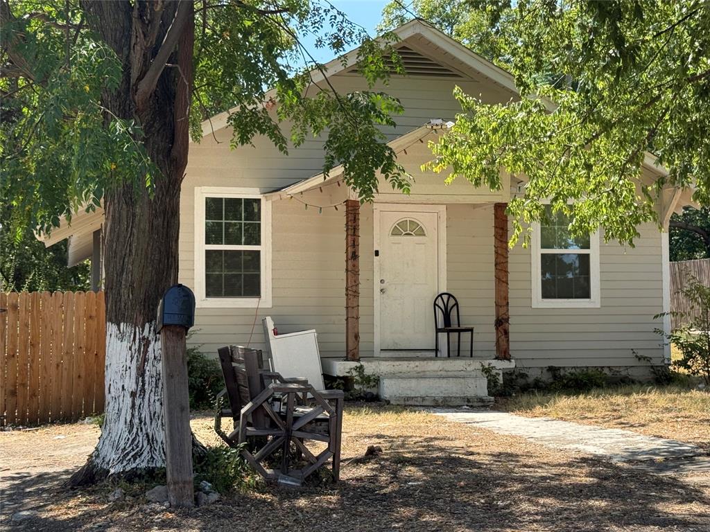 Front exterior featuring light-toned siding, white trim windows, and a covered porch with decorative wood posts Front exterior featuring light-toned siding, white trim windows, and a covered porch with decorative wood posts