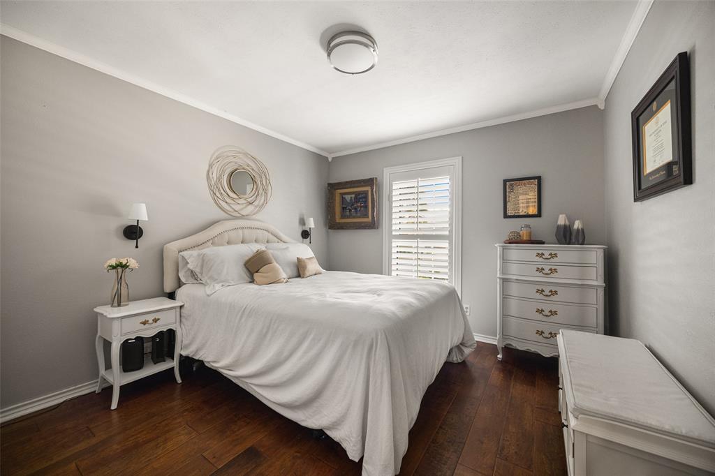 Wood-finish flooring, neutral wall color, crown molding, plantation shutters, and a ceiling-mounted light fixture