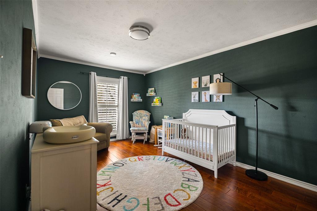 Hardwood flooring, painted walls, white crown molding, recessed lighting, and a flush-mount ceiling light