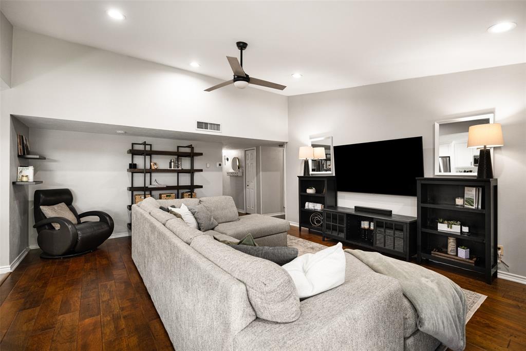 Vaulted ceiling with recessed lighting, wood-finish flooring, and a ceiling fan