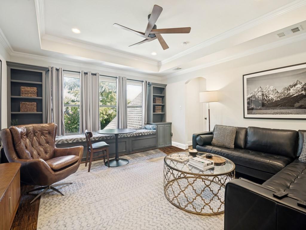 Large second level living area with wood floor, custom ceiling, recessed lighting and built-ins.