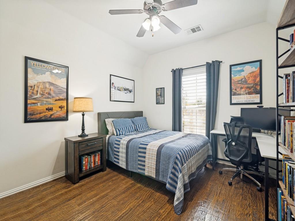 Upstairs secondary bedroom with wood floor and walk-in closet.