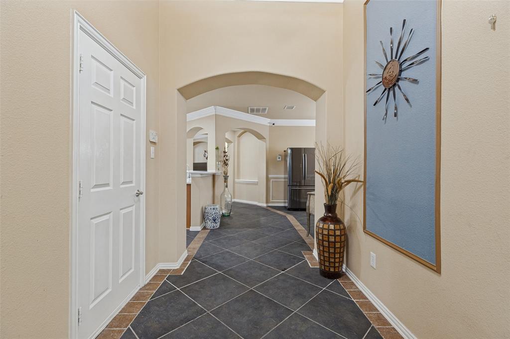 Arched doorways, dark tile flooring with a light tile border, and neutral wall tones