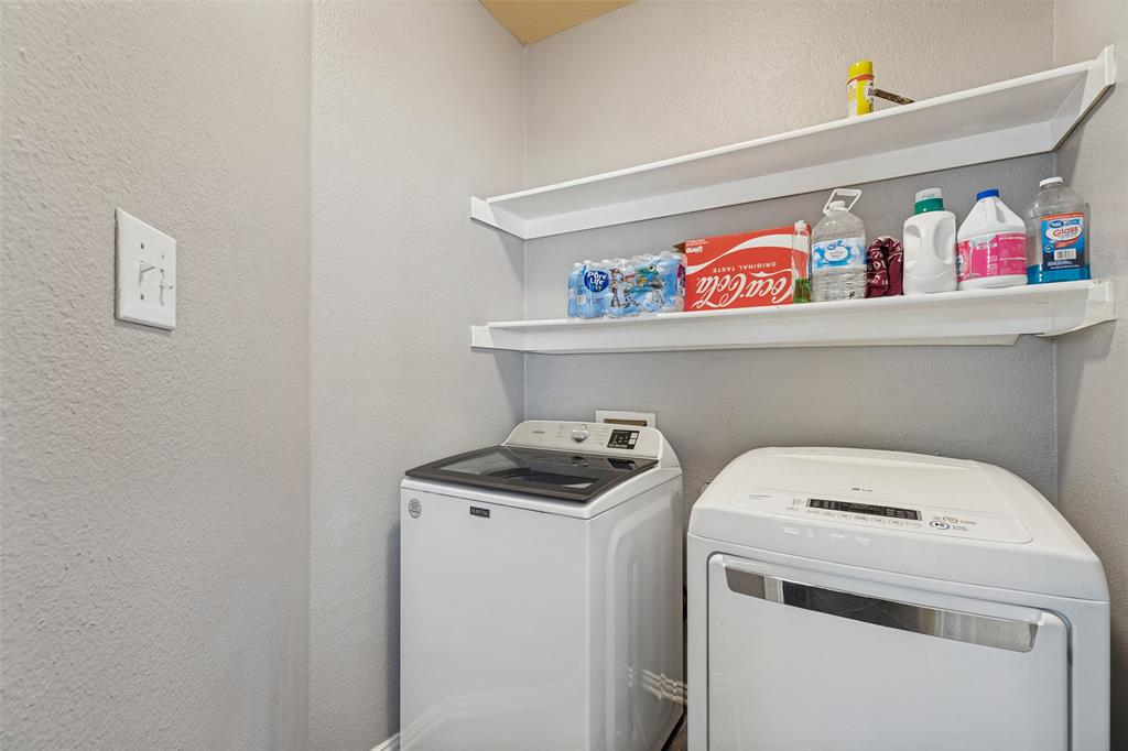 Laundry area with white upper shelving