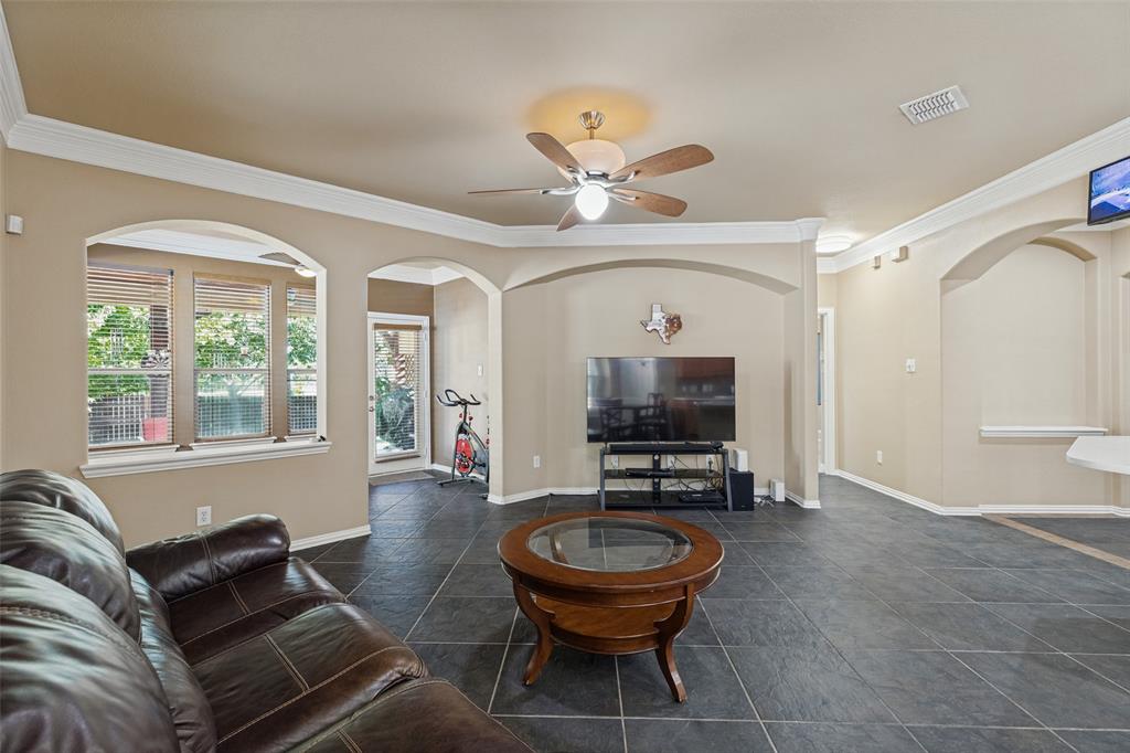 Archways, crown molding, a ceiling fan, and looking in to sun room