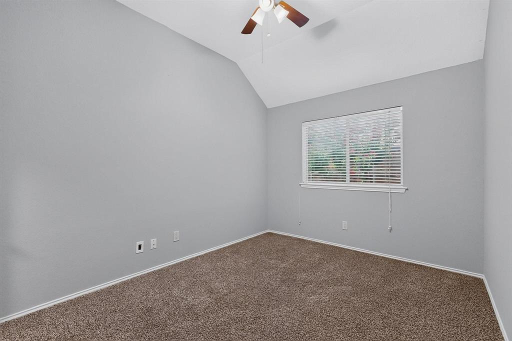 Vaulted ceiling with ceiling fan, window with blinds, and neutral carpet flooring