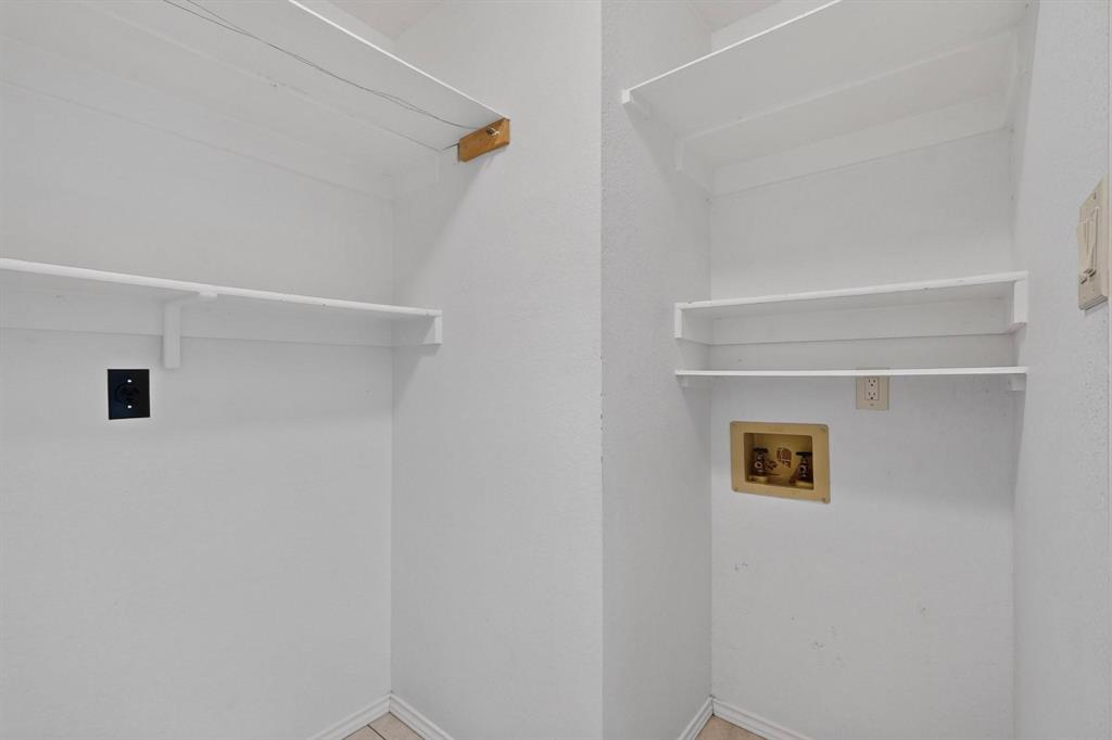 Laundry area featuring multiple storage shelves and utility hookups