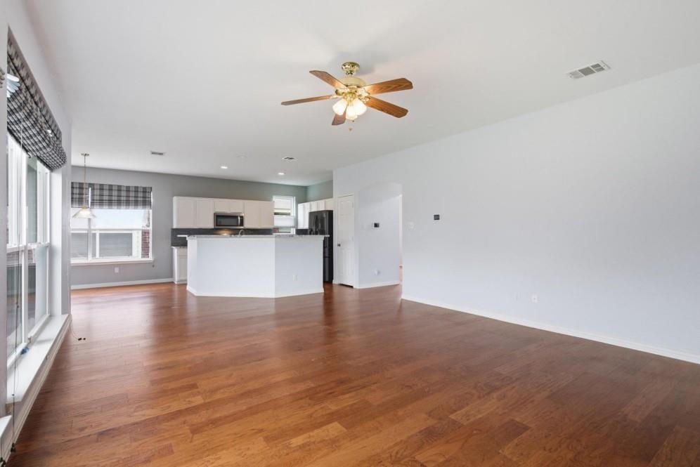 Wood-finish flooring throughout, with a ceiling fan and recessed lighting