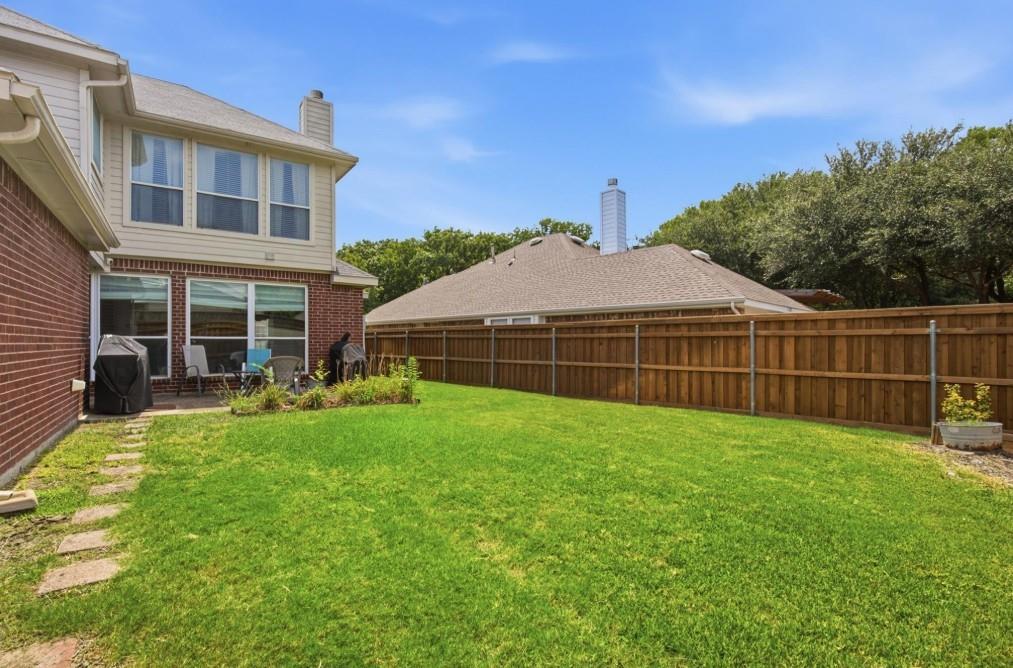 Expansive green lawn with a wood plank privacy fence