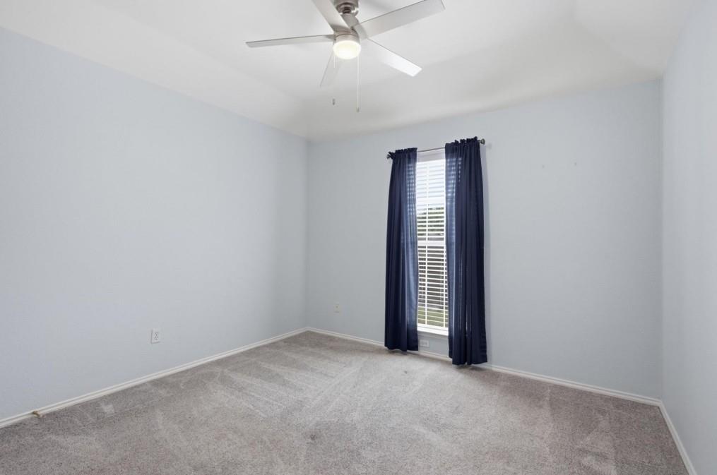 Recessed window featuring blinds, light gray wall finish, and gray carpet flooring